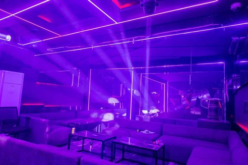 Ambiance violette et faisceaux au-dessus du carré VIP du Sky