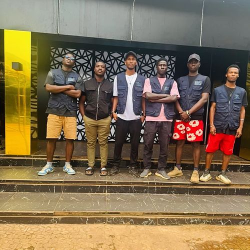 Les six membres de l'équipe Guinea Light en gilets floqués, devant un lieu qu'ils viennent d'équiper à Conakry